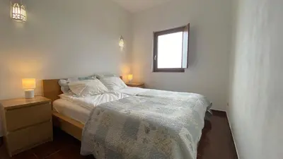 a small bedroom with a bed and a window at Casa do Miradouro in Carrapateira