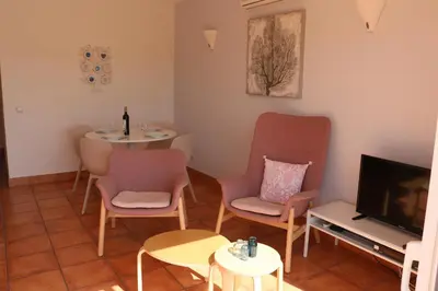 a living room with a table and chairs and a tv at Lagos Vila Mós 59 in Lagos