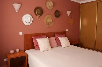 a bedroom with a bed with pink and white pillows at Lagos Vila Mós 59 in Lagos