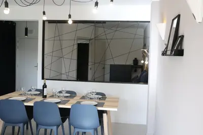 a dining room with a table and chairs and a large mirror at Lagos Beach 59A in Lagos