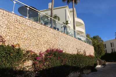 a retaining wall with flowers and a building at Lagos Beach 59A in Lagos