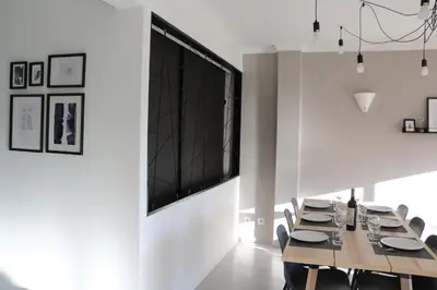 a dining room with a large television on the wall at Lagos Beach 59A in Lagos
