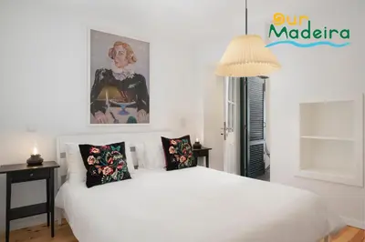 a white bedroom with a large white bed with pillows at OurMadeira - Heart of Old Town I in Funchal