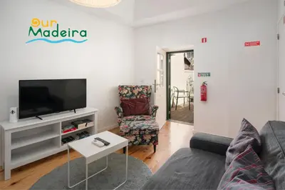 a living room with a couch and a tv at OurMadeira - Heart of Old Town II in Funchal