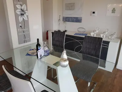 a glass table with two chairs and a counter with wine bottles at Madalenas Palace - Sunrise in Funchal