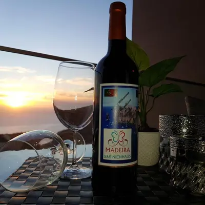 a bottle of wine sitting next to a glass of wine at Madalenas Palace - Sunrise in Funchal