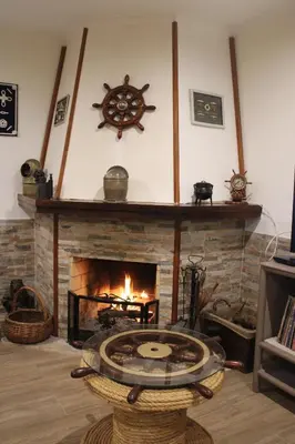 a living room with a fireplace with a clock on the wall at Abrigo das Nortadas in Vila do Bispo