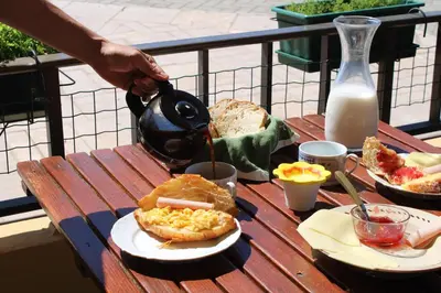a person pouring food into a tea pot on a table at Abrigo das Nortadas in Vila do Bispo