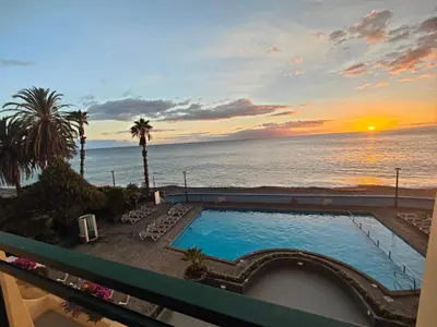 a view of the ocean from a balcony with a swimming pool at By the Beach & Pool Apartment in Funchal