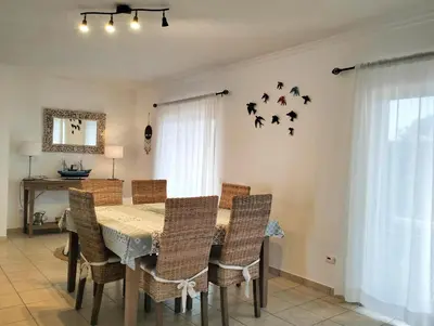 a dining room with a table with chairs and birds on the wall at VILLA ANDORINHA with Private Pool in a quiet area in Aljezur