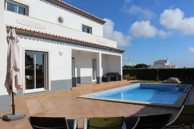 a swimming pool in front of a white house at VILLA ANDORINHA with Private Pool in a quiet area in Aljezur