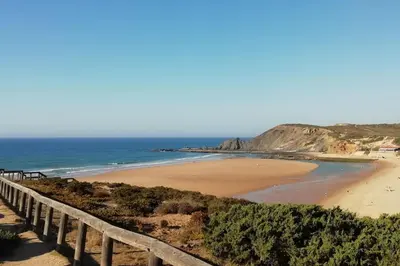 a beach with a wooden fence next to the ocean at VILLA ANDORINHA with Private Pool in a quiet area in Aljezur