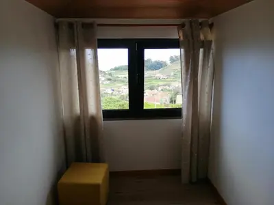 a room with a window and a yellow box at Recantos do Castanheiro in Porto Moniz