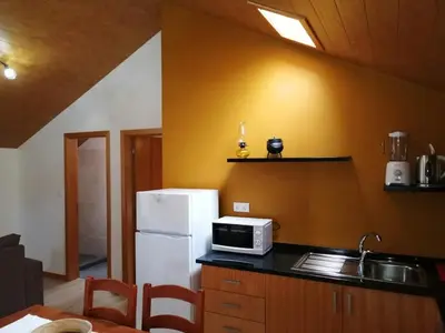 a kitchen with a white refrigerator and a microwave at Recantos do Castanheiro in Porto Moniz