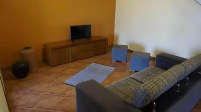 a living room with a couch and a tv at Recantos do Castanheiro in Porto Moniz