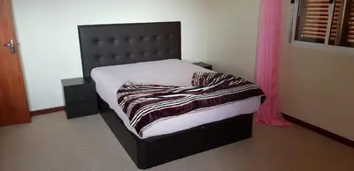 a bed in a bedroom with a black headboard at Casa da Lagoa in Calheta