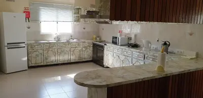 a kitchen with marble counter tops and a white refrigerator at Casa da Lagoa in Calheta