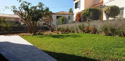 a yard with a retaining wall and a lawn with a house at Casa da Lagoa in Calheta