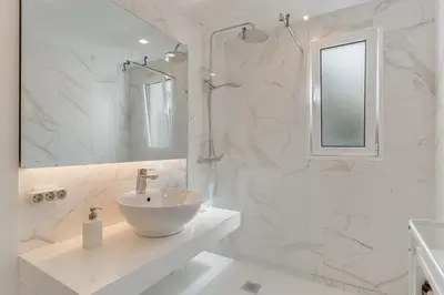 a white bathroom with a sink and a shower at Braganza apartment in Funchal