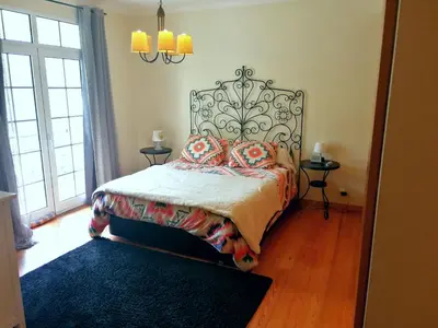 a bedroom with a bed with an ornate headboard at Casa do Vale in São Vicente