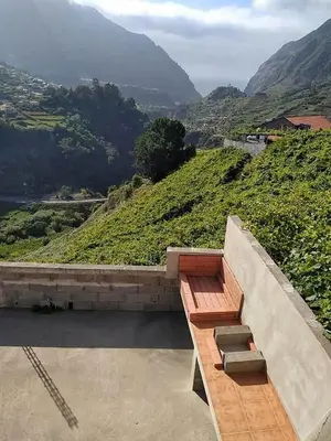 a wooden bench sitting on top of a hill at Casa do Vale in São Vicente