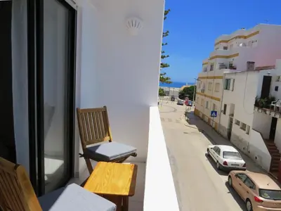 a balcony with a chair and a view of a street at IM On Luz Arte in Luz