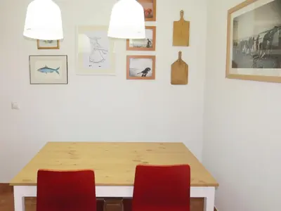 a dining room table with red chairs and pictures on the wall at IM On Luz Arte in Luz