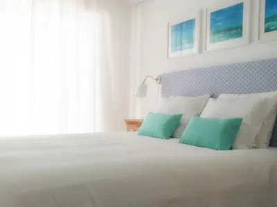a bedroom with a white bed with two green pillows at IM On Luz Arte in Luz