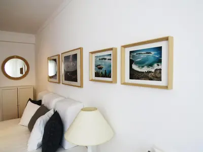 a bedroom with a white bed and four pictures on the wall at IM On Luz Arte in Luz