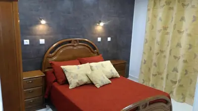 a bedroom with a bed with a red comforter at Vista Atlântico in Gaula