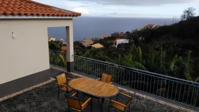 a table and chairs on a balcony with a view of the ocean at Vista Atlântico in Gaula
