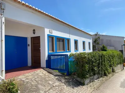 a blue and white house with a blue door at Apartamento Miradouro in Carrapateira