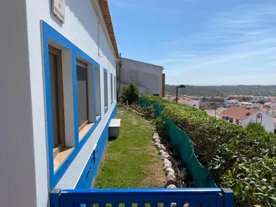 a blue and white building with a row of windows at Apartamento Miradouro in Carrapateira