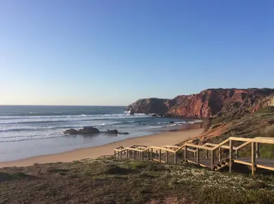 a beach with a bunch of chairs on the beach at Apartamento Miradouro in Carrapateira