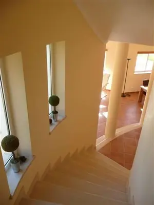 a staircase in a room with two potted plants at Lovely Burgau villa just 3 mins walk from beach in Budens