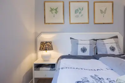 a bedroom with a bed and two pictures on the wall at Central Funchal Apartment - GARDEN - Free Parking & AC in Funchal