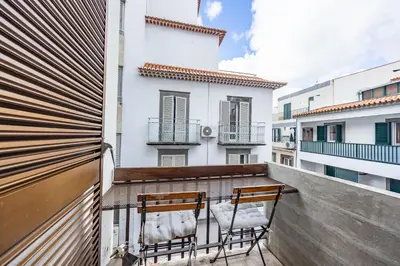a balcony with two chairs and a table at Central Funchal Apartment - GARDEN - Free Parking & AC in Funchal
