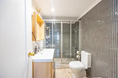 a bathroom with a toilet and a sink and a shower at Central Funchal Apartment - GARDEN - Free Parking & AC in Funchal