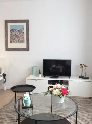 a living room with a glass table and a tv at CHARMING LIDO FLAT II in Funchal