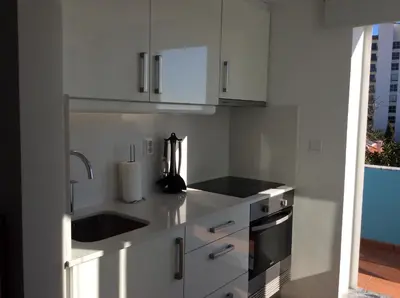 a kitchen with white cabinets and a sink at CHARMING LIDO FLAT II in Funchal