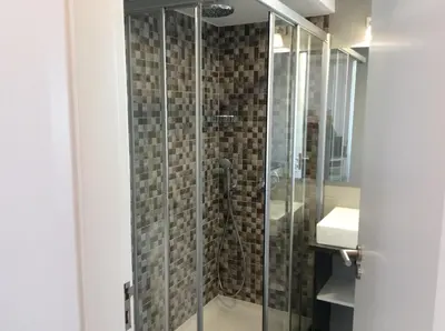 a shower with a glass door in a bathroom at CHARMING LIDO FLAT II in Funchal