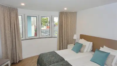 a bedroom with a bed and some windows at CHARMING LIDO FLAT II in Funchal