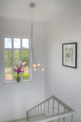 a white room with a vase of flowers in a window at Villa Montanha, 4 Bedroom Villa, with swimming pool, loungers and alfresco dining, 10 min walk to the beautiful Praia da Luz Beach, Shops, Bars and Restaurants! in Luz