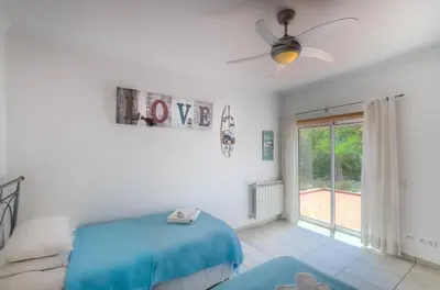 a bedroom with a bed and a ceiling fan at Villa Montanha, 4 Bedroom Villa, with swimming pool, loungers and alfresco dining, 10 min walk to the beautiful Praia da Luz Beach, Shops, Bars and Restaurants! in Luz