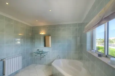 a bathroom with a tub and a sink and a window at Villa Montanha, 4 Bedroom Villa, with swimming pool, loungers and alfresco dining, 10 min walk to the beautiful Praia da Luz Beach, Shops, Bars and Restaurants! in Luz
