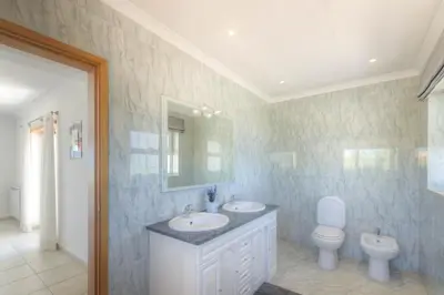 a bathroom with a sink and a toilet and a mirror at Villa Montanha, 4 Bedroom Villa, with swimming pool, loungers and alfresco dining, 10 min walk to the beautiful Praia da Luz Beach, Shops, Bars and Restaurants! in Luz