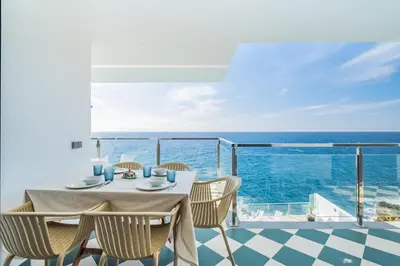 a table with chairs and a view of the ocean at Beach House - By WeHost in Santa Cruz