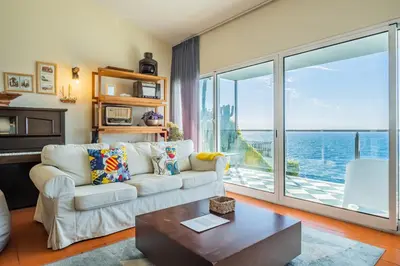 a living room with a couch and a view of the ocean at Beach House - By WeHost in Santa Cruz