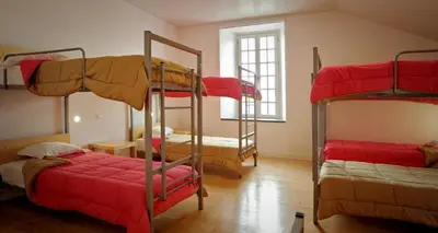 a room with three bunk beds with red sheets at Azores Youth Hostels - Santa Maria in Vila do Porto