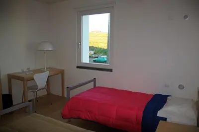 a bedroom with a red bed and a desk and a window at Azores Youth Hostels - Santa Maria in Vila do Porto